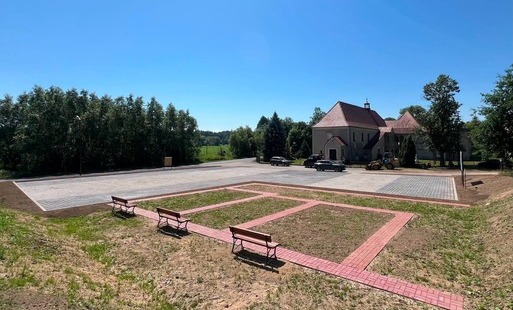 Zdjęcie przedstawia utwardzony teren przy kościele w Nawojowie Łużyckim 