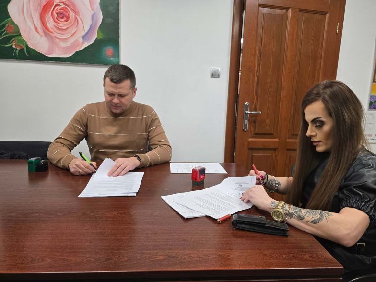 Zdjęcie przedstawia w&oacute;jt gminy Lubań podpisującą umowę