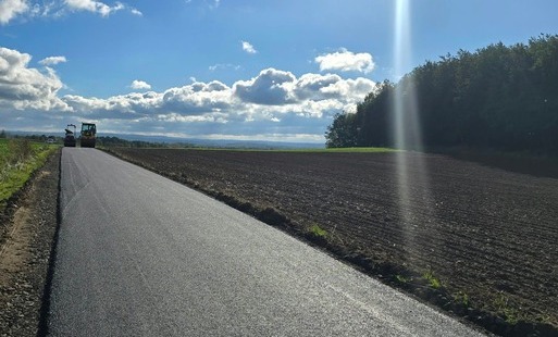 Zdjęcie przedstawia nową nawierzchnie asfaltową na drodze dojazdowej do gruntów rolnych w Pisarzowicach